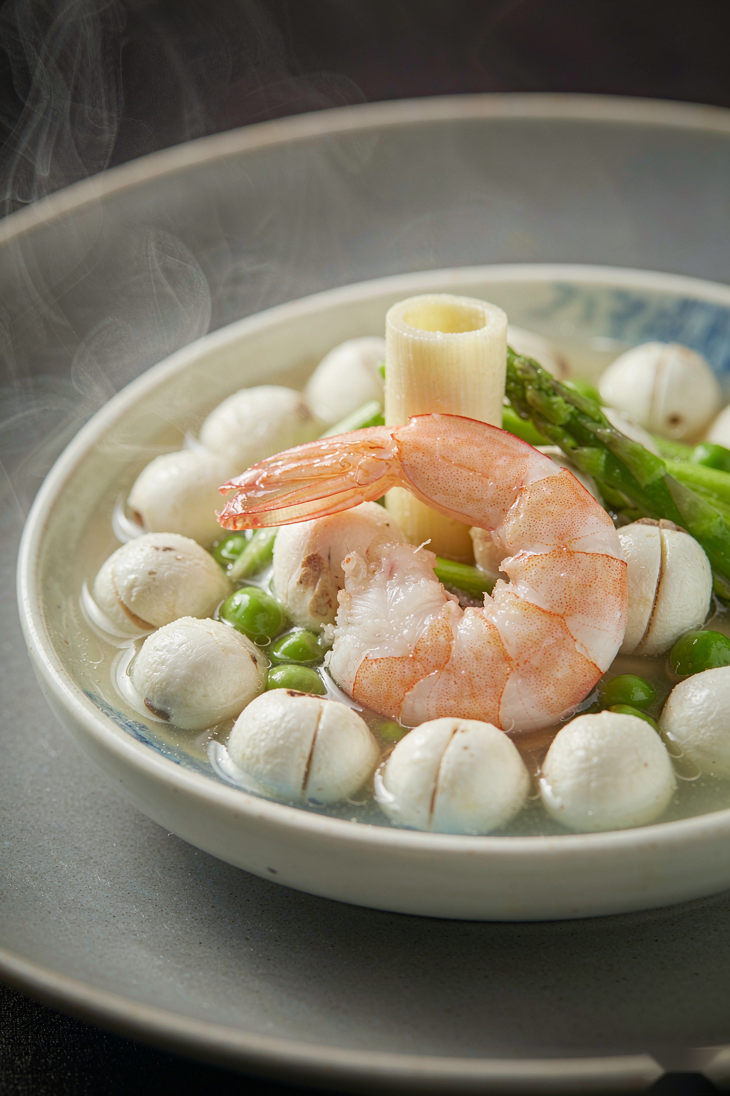 Macro close-up of Wudang Euryale & Shrimp Light Bowl showing plump shrimp, round euryale seeds, peas and asparagus in clear broth with rising steam