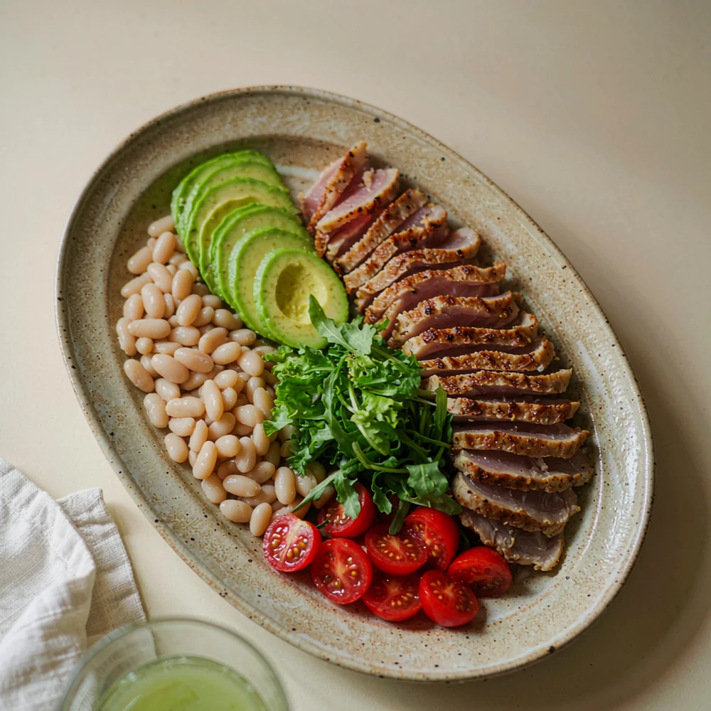 No-cook tuna avocado plate — canned tuna, sliced avocado, chickpeas and greens on a speckled stoneware plate