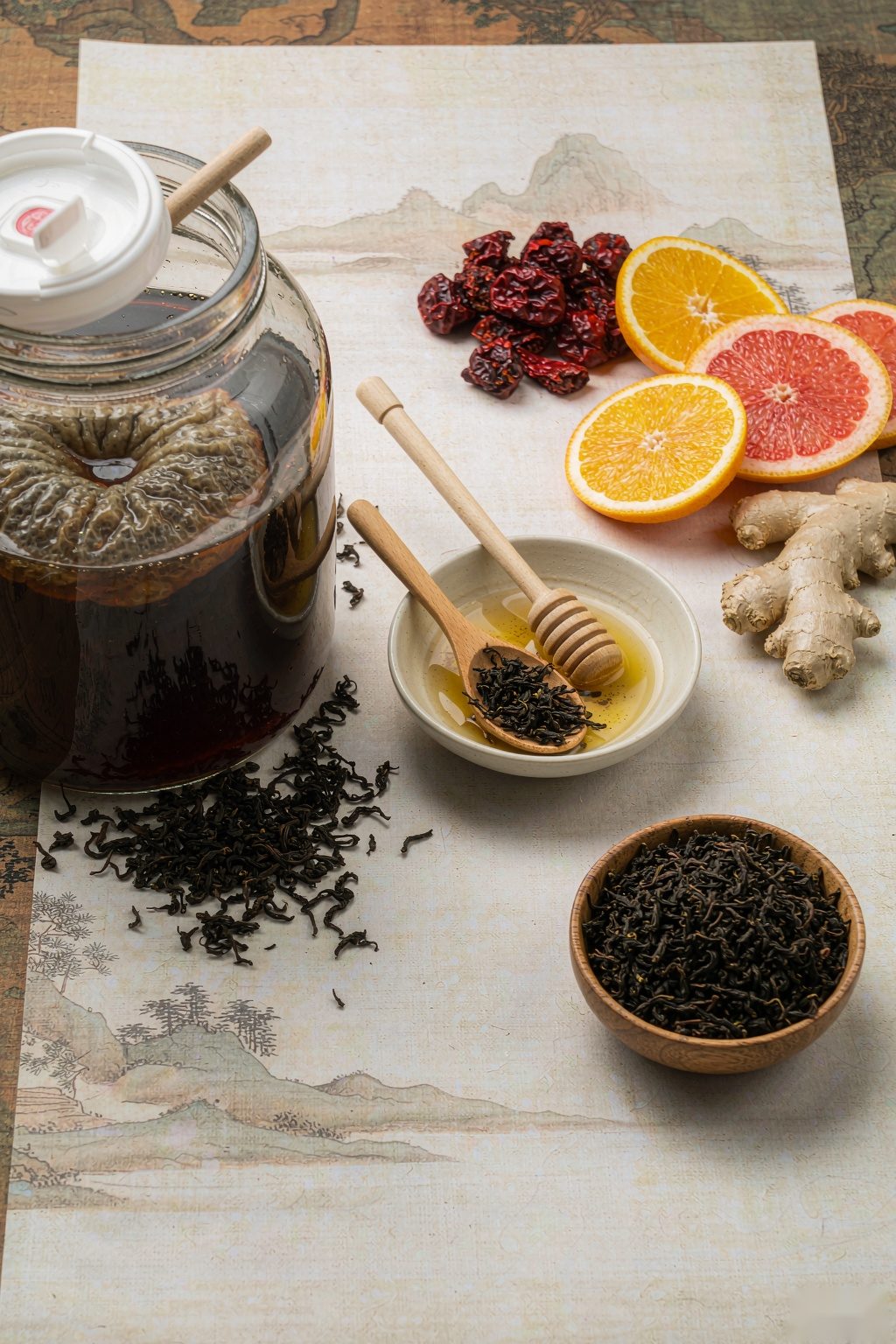Oolong Kombucha ingredients flat lay: oolong leaves, scoby culture, citrus, ginger and honey