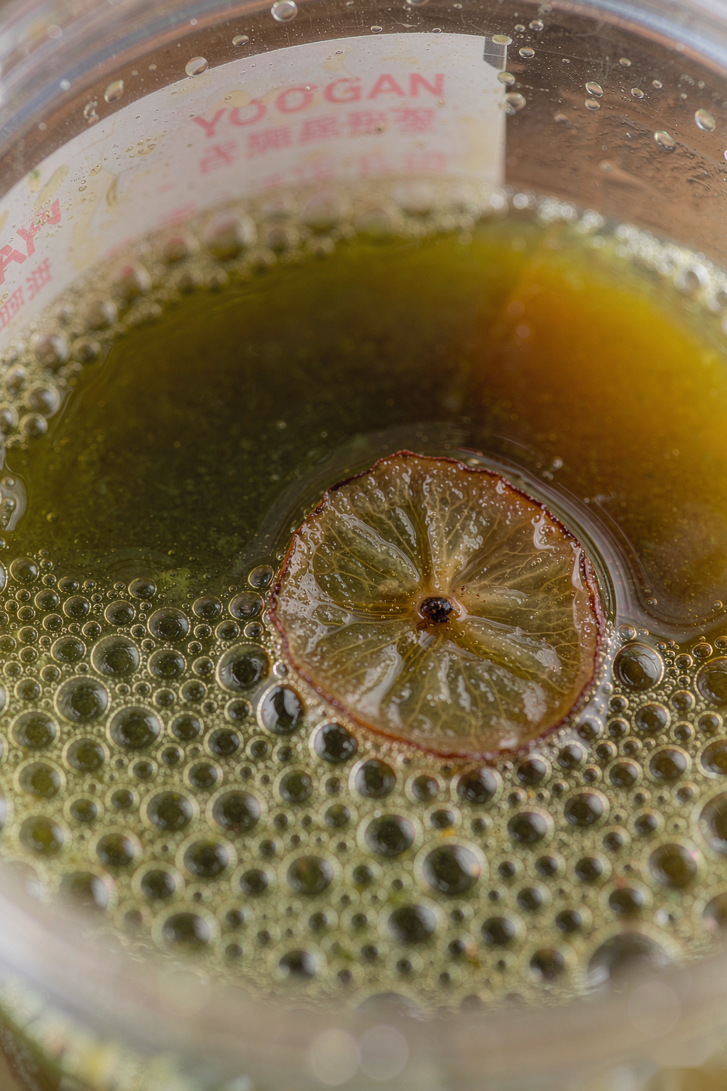 Macro of Yougan Prune Detox Drink surface with bubbles and prune slice